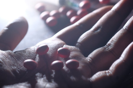 drug abuse concept with pills on hand on table