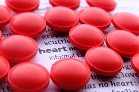 close up of red pills on dictionary, save heart conceptの写真素材