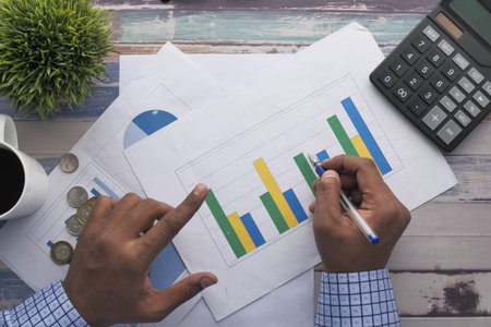 top view of man hand analyzing financial chart on paper