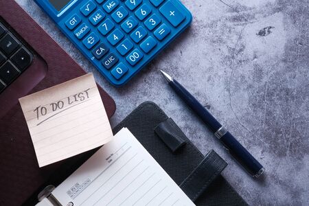 to do list on notepad with laptop and calculator on desk .の写真素材