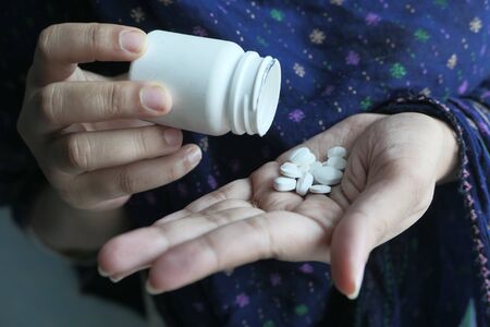 Close up of pills on palm of women hand.の写真素材