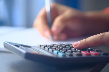 Closeup of women hand using calculator .の写真素材