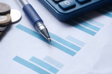 Close up of bar chart, coin and penの写真素材
