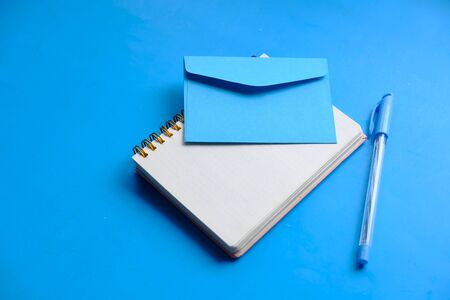 Close up of envelope and notepad on table .の写真素材