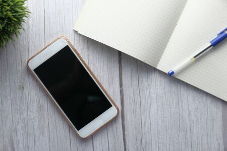 top view of smart phone and notepad on tableの写真素材
