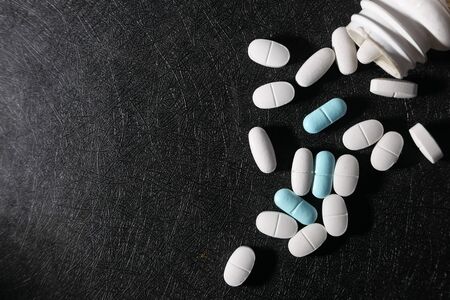 high angle view of white pill spilling from containerの写真素材