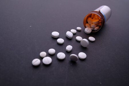 Close up of white pills spilling on tableの写真素材