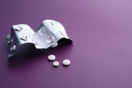 Close up of white pills and tablet on color backgroundの写真素材