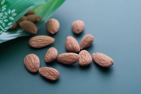 Close up of fresh and raw almond on green background.の写真素材