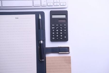top view of office desk with calculator and notepad.の写真素材