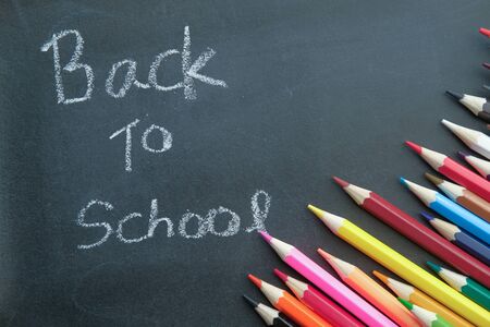 back to school text on blackboard with color pencils.の写真素材