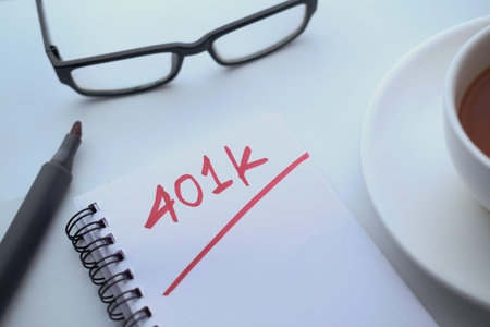 top view of 401k text on notepad with tea on table.