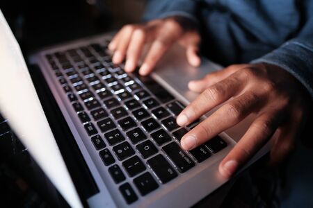 hooded hacker sealing data from laptop.の写真素材