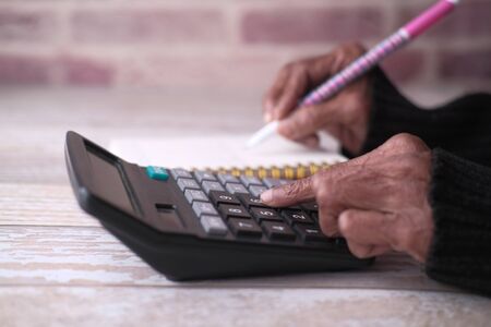Close up of senior women hand use calculatorの写真素材