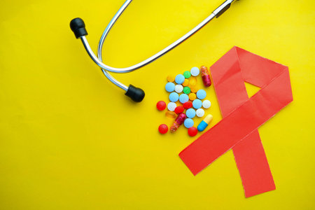Close up of HIV symbol and pills on yellow background.