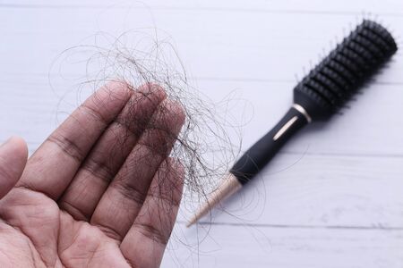 Healthy concept. Woman show her brush with damaged long loss hairの写真素材