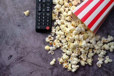 top view of popcorn and tv remote on table.の写真素材
