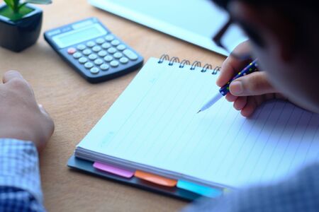 businessman writing on notepad at office des.の写真素材