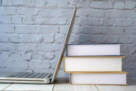 close up of stack of books and laptop on tableの写真素材
