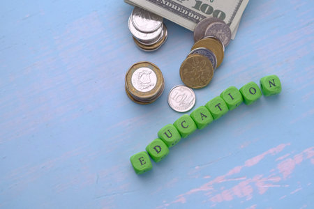 top view of education text and coin on table. saving money for education concept