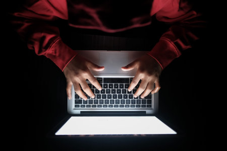  hacker sealing data from laptop at night, close up .