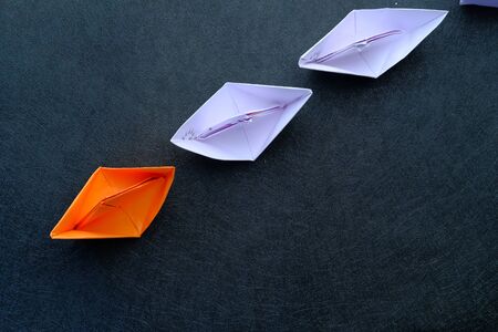 leadership concept with paper boat on table , top view.の写真素材