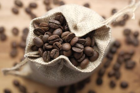 Close up of fresh and raw coffee beans in a bag on tableの写真素材