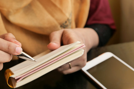 close up of women hand writing on notepad