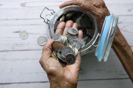 top view of senior women saving coins in a jarの写真素材