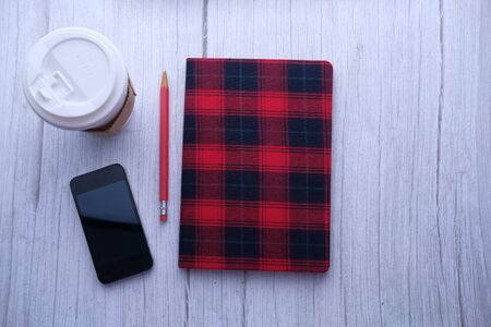 top view of smart phone, notepad and tea on tableの写真素材