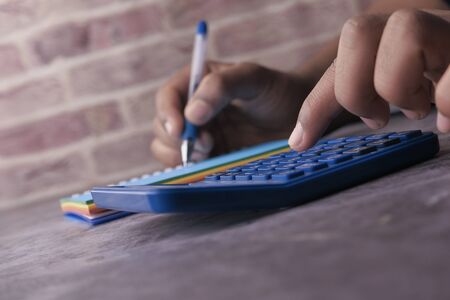 Close up of man hand use calculator on office deskの写真素材