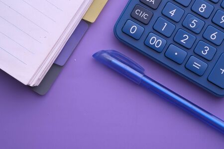 top view of notepad, calculator and pen on table.の写真素材