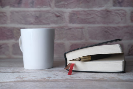 tea cup, fountain pen and open diary on table