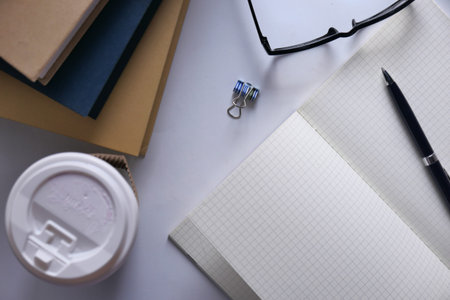 top view of open notepad, book and tea on table