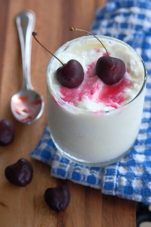 close up of cheery fruit on yogurt in a jar.の写真素材