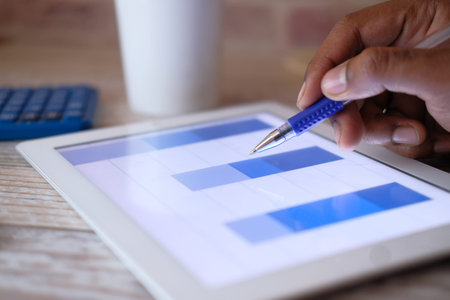 Close up of man hand analyzing chart on digital tablet