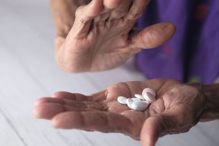 close up of senior women hand taking pillsの写真素材