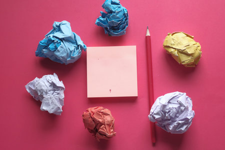 close up of crumpled paper ball on pink background