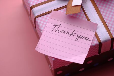thank you message on gift box on pink background .の写真素材