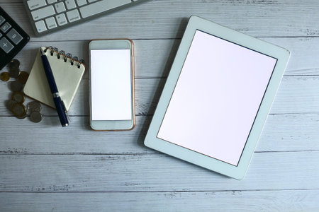 top view of digital tablet and notepad on orange background