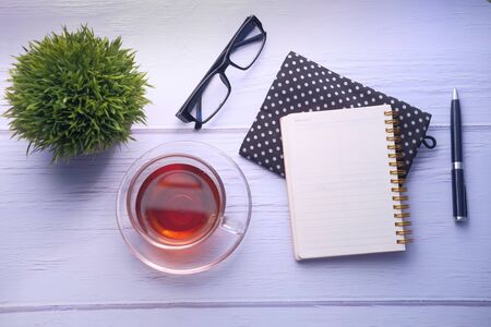 top view of open notepad and eyeglass on table.の写真素材