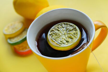 flue and fever concept. close up of lemon tea on yellow background.の写真素材