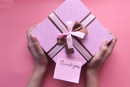 top view of women hand holding pink gift box.の写真素材