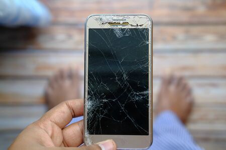 top view of person hand holding damage smart phone.の写真素材