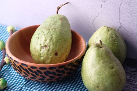 Close up of guava in a wooden bowl on tableの写真素材