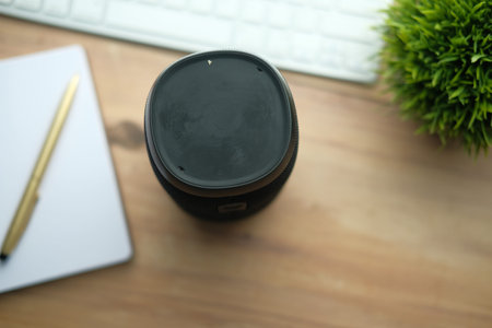 Smart home device speaker lit up on wooden desk