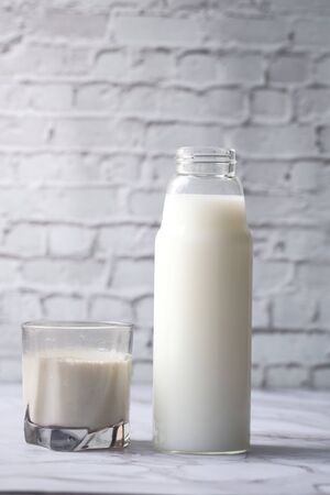 fresh milk in a glass and bottle on table.の写真素材