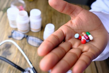 The doctors hands holds multi color pills.の写真素材