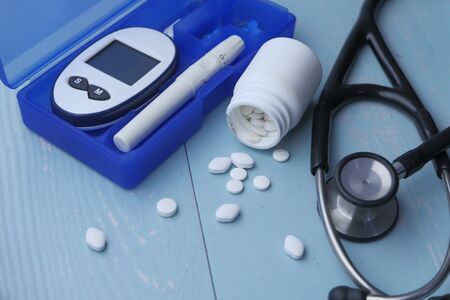 Glucometer, blood sugar measurement for diabetes, pills and stethoscope.の写真素材
