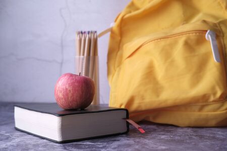 apple on stack of book with school bag and head phoneの写真素材